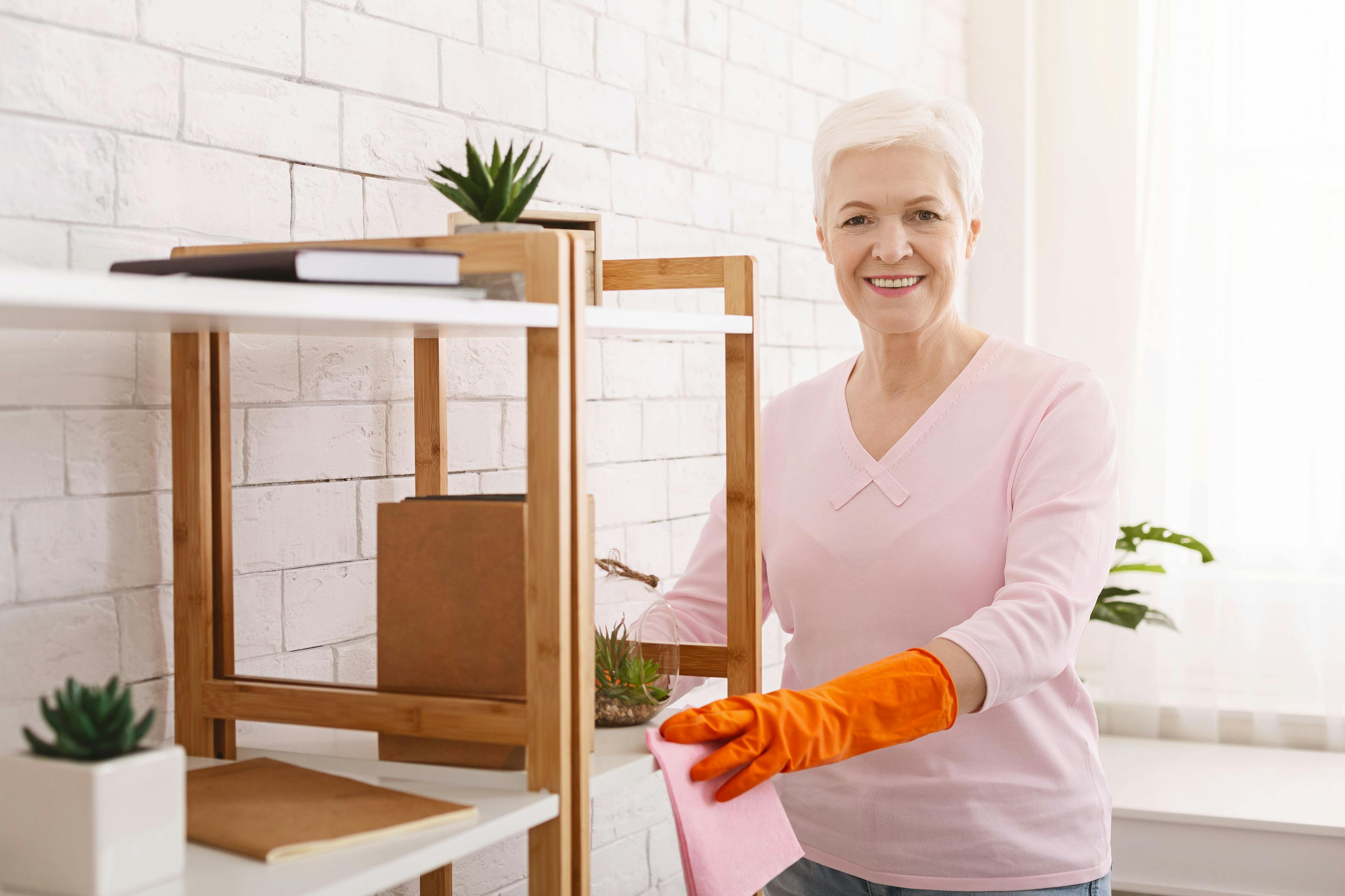 Eine Seniorin putzt ihre Wohnung