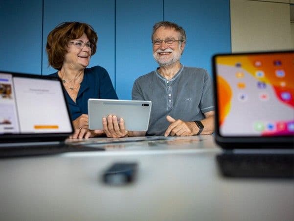 Zwei Senioren besuchen ein Webinar der Swisscom.