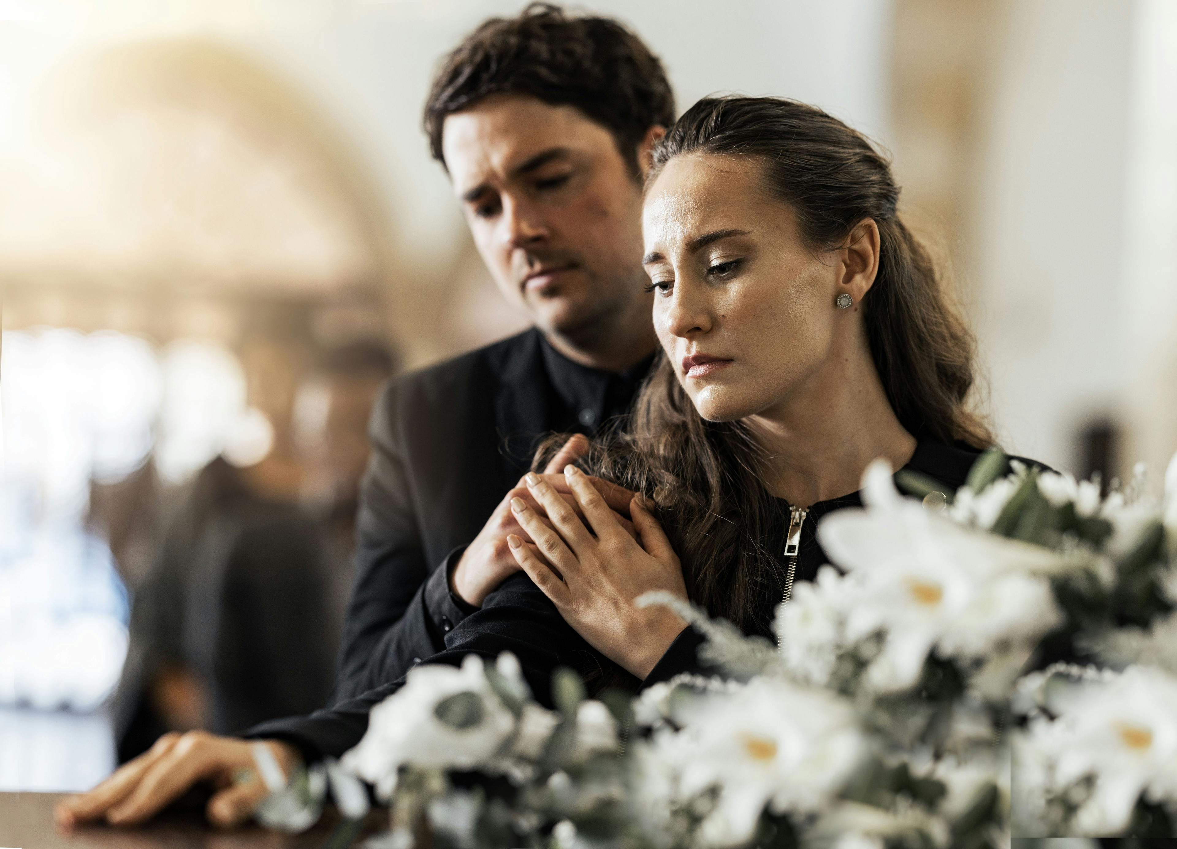 Bestattungsvorsorge: Eine Frau und ein Mann an einer Beerdigung.